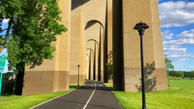This video shows a view of the Hell Gate bridge in Bronx, NY.  The Hell Gate Bridge, originally the New York Connecting Railroad Bridge or the East River Arch Bridge, is a 1,017-foot steel through arch railroad bridge in New York City.