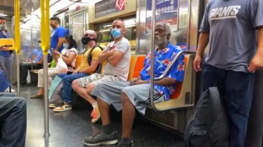 This video shows views of people wearing a face mask during the Coronavirus era on a subway train while heading from Brooklyn to downtown Manhattan.