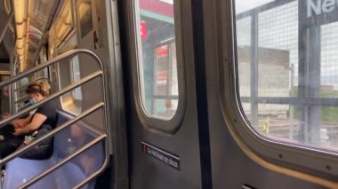 This video shows views of people wearing a face mask during the Coronavirus era on a subway train while heading from Brooklyn to downtown Manhattan.