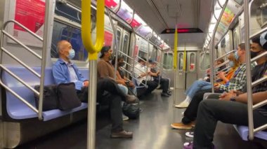 This video shows views of people wearing a face mask during the Coronavirus era on a subway train while heading from Brooklyn to downtown Manhattan.