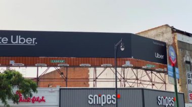 This video shows views of businesses and a billboard sign near Barclays Center in downtown Brooklyn.  Barclays Center is a multi-purpose indoor arena in the New York City borough of Brooklyn and is home to the NBAs Brooklyn Nets. 