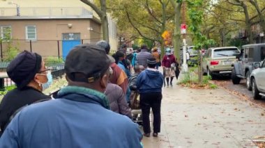 This video shows a line of African American people coming out early to vote for a new president in the critical 2020 presidential election during a Covid-19 pandemic.  