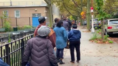 This video shows a line of African American people coming out early to vote for a new president in the critical 2020 presidential election during a Covid-19 pandemic.  