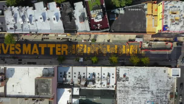 この空中ビデオは ニューヨーク州ブルックリンのフルトン通りで描かれた黒い生き物の壁画の風光明媚な鳥の目のビューを示しています — ストック動画