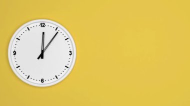 Sarı duvar saati beyaz arkaplanda izole edilmiş, saat dakikası yavaş yürü, zaman kavramı.