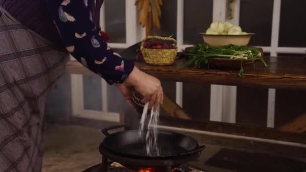 Pouring Salt Large Water Filled Pan Burning Wood Fire — Stockvideo