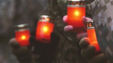 Unutmayalım diye hatırlatma günü. Mumlu Anma Günü. Anma mumları yanıyor. Askeri üniformalı Ukraynalı askerler ellerinde kırmızı mumlarla. Askeri geçit törenindeki askerler.