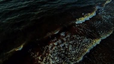 Sonbaharda karanlık deniz suyu. Pasifik Okyanusu 'nun kayalık kıyıları, kayalara vuran deniz suyu dalgaları. Dramatik günbatımı doğası. Denizin üzerinde insansız hava aracı uçuşu.