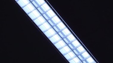 Siyah arka planda LED doğrusal ışık. Bantlı lamba siyah bir arka planda yavaşça açılıp kapanıyor. Enerji tasarrufu kavramı