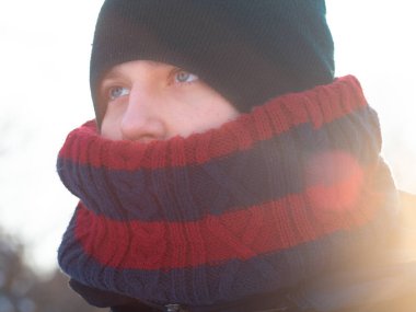 Kışın sıcacık giyinmiş bir genç. Kışın atkı ve şapkası olan bir öğrenci.