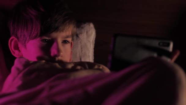 Elinde Telefonla Battaniyenin Altında Yatan Bir Çocuk Küçük Çocuk Yatakta — Stok video