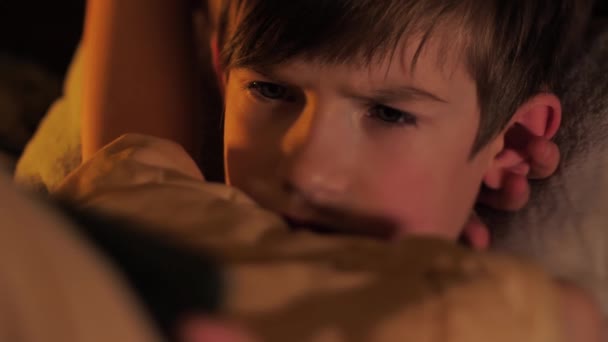Ein Kind Bett Unter Einer Decke Das Telefon Der Hand — Stockvideo