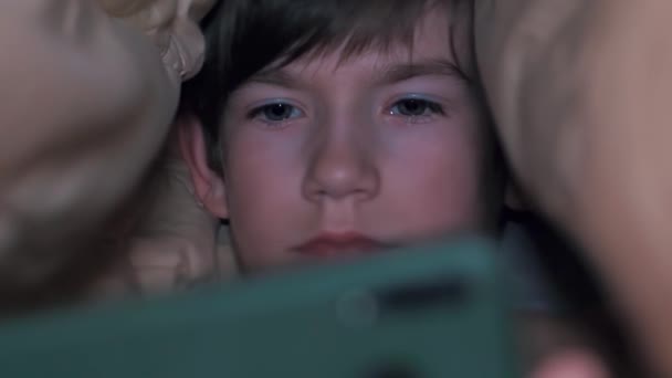 Ένα Παιδί Στο Κρεβάτι Κάτω Από Μια Κουβέρτα Ένα Τηλέφωνο — Αρχείο Βίντεο