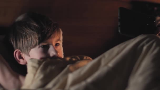 Enfant Lit Sous Une Couverture Avec Téléphone Dans Les Mains — Video