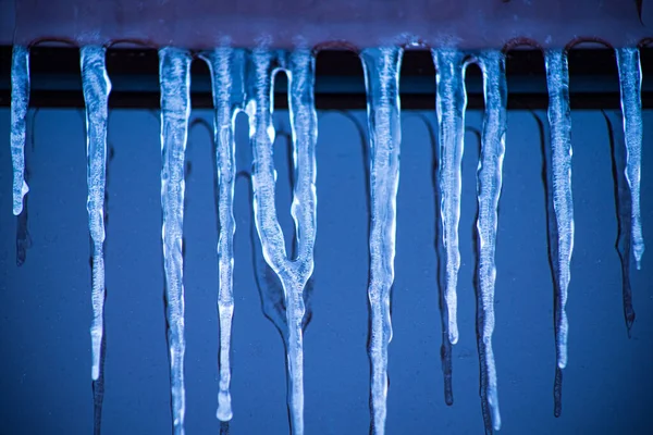 冰柱靠近窗户 用冰柱把大楼的门面涂成玻璃状 寒冷的天气里 窗上的冰 冰冰柱上的软焦点 — 图库照片