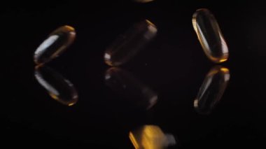 Kapsüllerdeki balık yağı siyah aynaya düşer. Vitaminli kapsüller