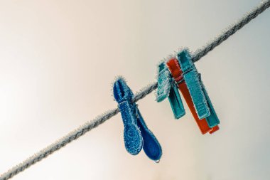 Elbise askıları kışın çamaşır ipine asılıydı. Kışın buz kristalleri olan giysiler için askılar.