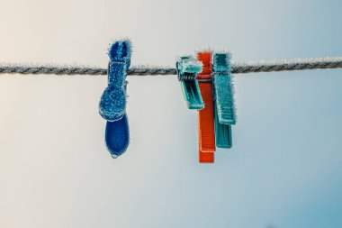 Elbise askıları kışın çamaşır ipine asılıydı. Kışın buz kristalleri olan giysiler için askılar.