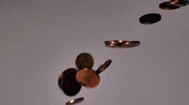 Para üstü masaya düşer. Yukardan gelen küçük bozuk paralar. Ağır çekimde masaya düşen az miktardaki avro sikkeleri. Bozukluklara yumuşak seçici odak