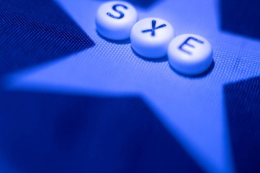 Letter word SEX with hearts in the form of an LGBT flag. lgbt rights concept. Soft selective focus on the letters sex. Letters on the American flag