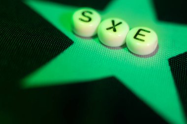 Letter word SEX with hearts in the form of an LGBT flag. lgbt rights concept. Soft selective focus on the letters sex. Letters on the American flag
