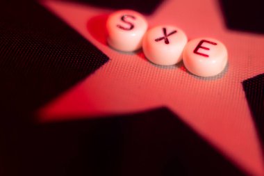 Letter word SEX with hearts in the form of an LGBT flag. lgbt rights concept. Soft selective focus on the letters sex. Letters on the American flag
