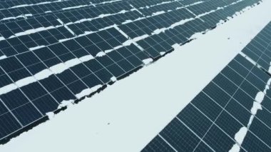 Bir dron güneş panellerinin üzerinden uçuyor. Yenilenebilir yeşil enerji ve elektrik teknolojileri. Güneş paneli kışın elektrik üretim alanlarında hizalanır. Yeşil enerji kavramı.