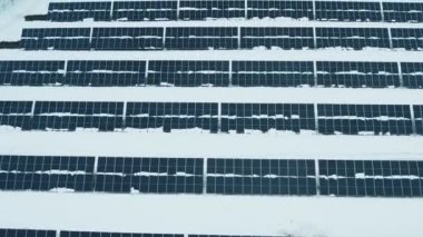 Bir dron güneş panellerinin üzerinden uçuyor. Yenilenebilir yeşil enerji ve elektrik teknolojileri. Güneş paneli kışın elektrik üretim alanlarında hizalanır. Yeşil enerji kavramı.