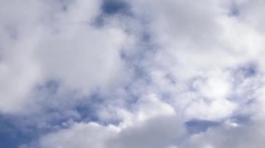 White fluffy cumulus clouds are flying, fast moving blue sky on a cloudy winter day. Blue sky white clouds. Cumulus cloud cloudscape timelapse. Fast moving white clouds and blue sky.