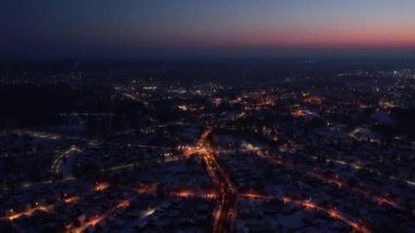 Gün batımında parlayan bir şehrin üzerinden uçmak. Şehrin fener ışıkları yukarıdan. Yukarıdan küçük bir kasaba. Seçici yumuşak odak