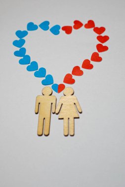 Erkek ve dişi LGBT 'yi sever. Evlilikte aile simgeleri. Bir çift sevgili. Bir kadın ve bir erkek el ele tutuşuyorlar. Kağıt mavisi ve kırmızı kalpli tahta insanlar.