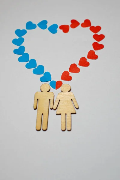 stock image Male and female love LGBT. In marriage, family icons. Couple of lovers. A woman and a man are holding hands. Wooden people with paper blue and red hearts