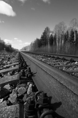 Tren için tren rayları. Kırsal bir bölgede demiryolu rayları. Demiryolu ile sanayi manzarası. İlkbaharda eski demiryolu. Köyde demiryolu olan eski bir demiryolu..