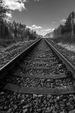 Tren için tren rayları. Kırsal bir bölgede demiryolu rayları. Demiryolu ile sanayi manzarası. İlkbaharda eski demiryolu. Köyde demiryolu olan eski bir demiryolu..