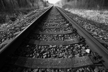 Tren için tren rayları. Kırsal bir bölgede demiryolu rayları. Demiryolu ile sanayi manzarası. İlkbaharda eski demiryolu. Köyde demiryolu olan eski bir demiryolu..
