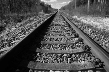 Tren için tren rayları. Kırsal bir bölgede demiryolu rayları. Demiryolu ile sanayi manzarası. İlkbaharda eski demiryolu. Köyde demiryolu olan eski bir demiryolu..