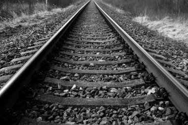 Tren için tren rayları. Kırsal bir bölgede demiryolu rayları. Demiryolu ile sanayi manzarası. İlkbaharda eski demiryolu. Köyde demiryolu olan eski bir demiryolu..