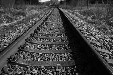 Tren için tren rayları. Kırsal bir bölgede demiryolu rayları. Demiryolu ile sanayi manzarası. İlkbaharda eski demiryolu. Köyde demiryolu olan eski bir demiryolu..