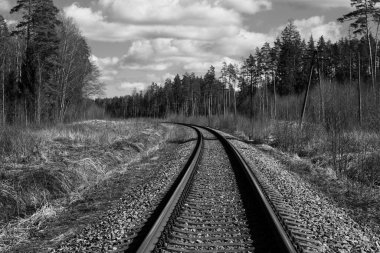 Tren için tren rayları. Kırsal bir bölgede demiryolu rayları. Demiryolu ile sanayi manzarası. İlkbaharda eski demiryolu. Köyde demiryolu olan eski bir demiryolu..