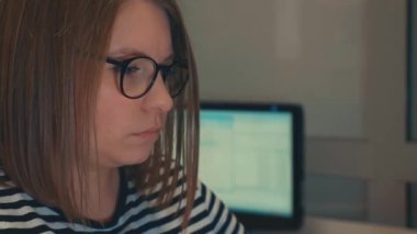 Bir kız üniversite öğrencisi bilgisayar kullanıyor. Uzaktan öğrenme çevrimiçi seminer sınıfı. Endişeli kadın bilgisayar düşünme problemini çözmeye çalışıyor. Bilgisayarda çalışan genç iş kadınının yan görünüşü