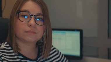 Bir kız üniversite öğrencisi bilgisayar kullanıyor. Uzaktan öğrenme çevrimiçi seminer sınıfı. Endişeli kadın bilgisayar düşünme problemini çözmeye çalışıyor. Bilgisayarda çalışan genç iş kadınının yan görünüşü