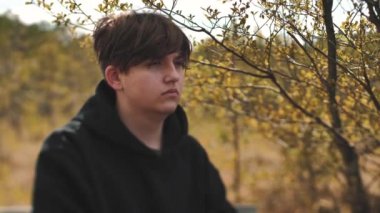 Bir adam doğada yalnız zaman geçirir. Yalnızlık ve hayat hakkındaki düşünceler. Bunalımlı genç bir adam kendisiyle yalnız. Yumuşak seçici odak.