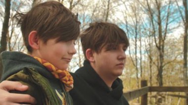 Küçük kardeş ağabeyiyle selfie çekiyor. Arkadaşlar ilkbaharda birlikte zaman geçirirler. Çocuklar kameraya gülümsüyor. Çocuklar dışarıda yalnız vakit geçirir. Yumuşak seçici odak.