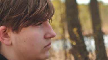 Bir adam doğada yalnız zaman geçirir. Yalnızlık ve hayat hakkındaki düşünceler. Bunalımlı genç bir adam kendisiyle yalnız. Yumuşak seçici odak.