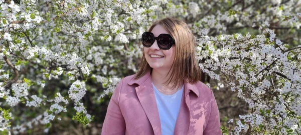 Fiatal Gyönyörű Napszemüvegben Rózsaszín Kabát Pózol Közel Virágzó Akác Egy — Stock Fotó