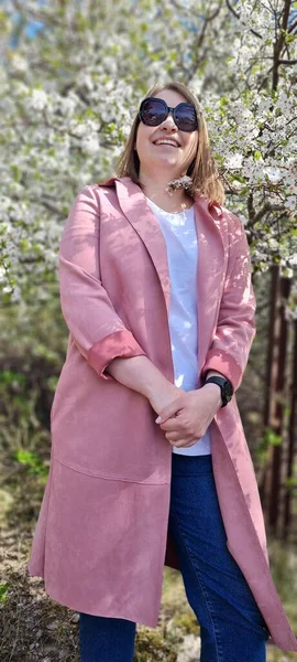 Молодая Красивая Женщина Солнечных Очках Розовое Пальто Позирует Возле Цветущей — стоковое фото