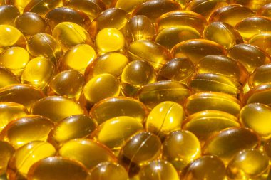 Güneş ışığında Omega kapsülleri. Güneş ışığı kapsüllerdeki balık yağını yansıtır. Doğru beslenme