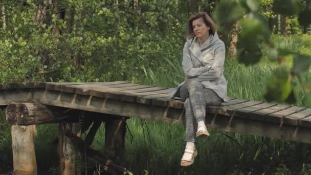 Μια Γυναίκα Κάθεται Μια Ξύλινη Γέφυρα Καταθλιπτική Κατάσταση Κοντινό Πλάνο — Αρχείο Βίντεο