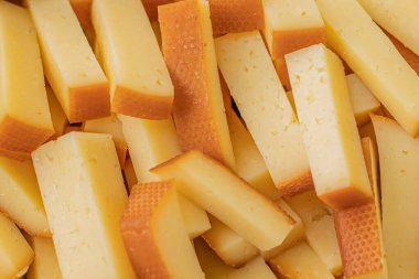 Peynirli atıştırmalıklar bir konteynırda. Farklı şekillerde dilimlenmiş peynir. Kutlama için peynir tahtası.