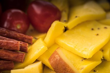 Peynirli atıştırmalıklar bir konteynırda. Farklı şekillerde dilimlenmiş peynir. Kutlama için peynir tahtası.